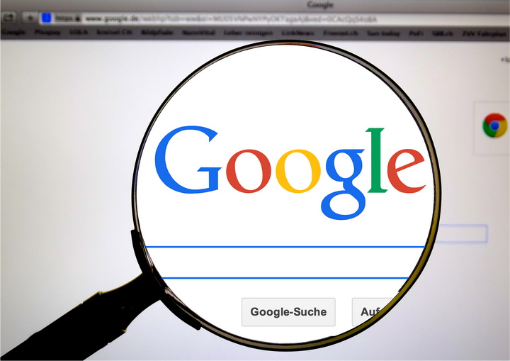 An image of a magnifying glass over Google search